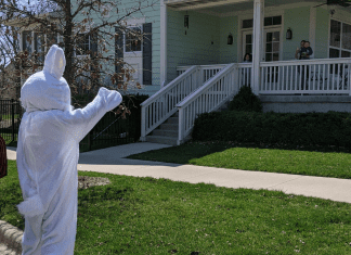 The easter bunny waves to a house and family