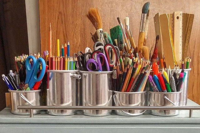 metals tins with colored pencils and paintbrushes