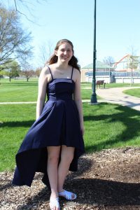 Young woman in park in navy blue prom dress